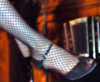 Fishnet stockings and high-heeled shoe.