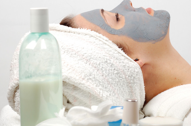 Woman relaxing with a facial mask at a spa.