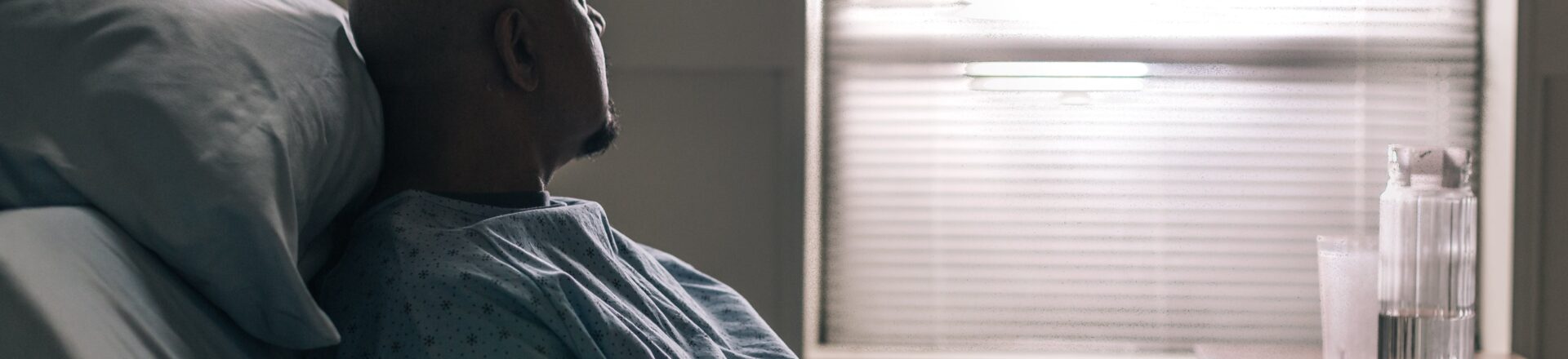 Man in hospital bed dealing with hiccups that won’t go away, reflecting exhaustion and search for relief