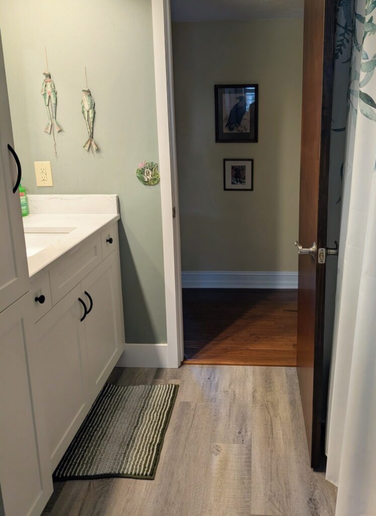 Softly lit bathroom with open doorway symbolizing calm, safety, and nervous system relaxation.